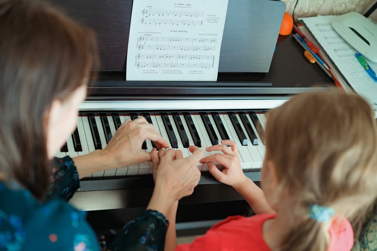 Two people learning at the piano together